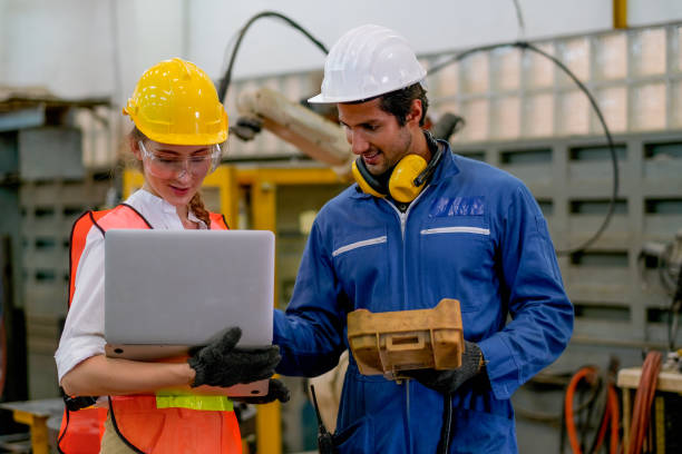 Factory technicians programming an industrial robotic arm on the shop floor